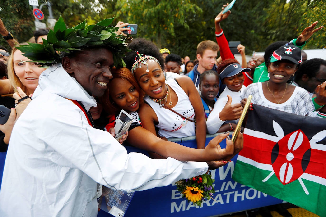 Kipchoge cruza la línea de meta de la maratón de Berlín en primera posición, batiendo el récord del mundo y con la puerta de Brandenburgo de fondo