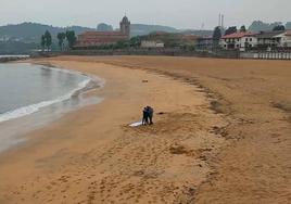 Agentes en la playa de Luanco, donde ha sido hallado un cadáver.