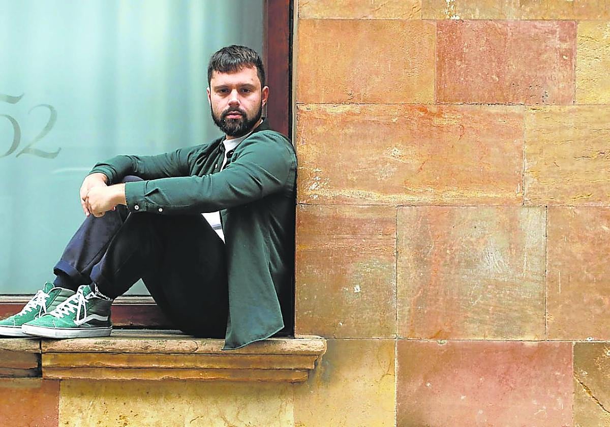 Xaime Martínez, sentáu nun ventanal n'Uviéu.