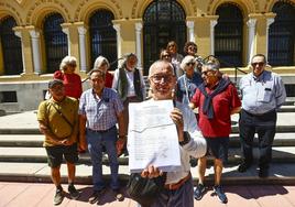 Los vecinos muestran las firmas recogidas ante el edificio de Presidencia.