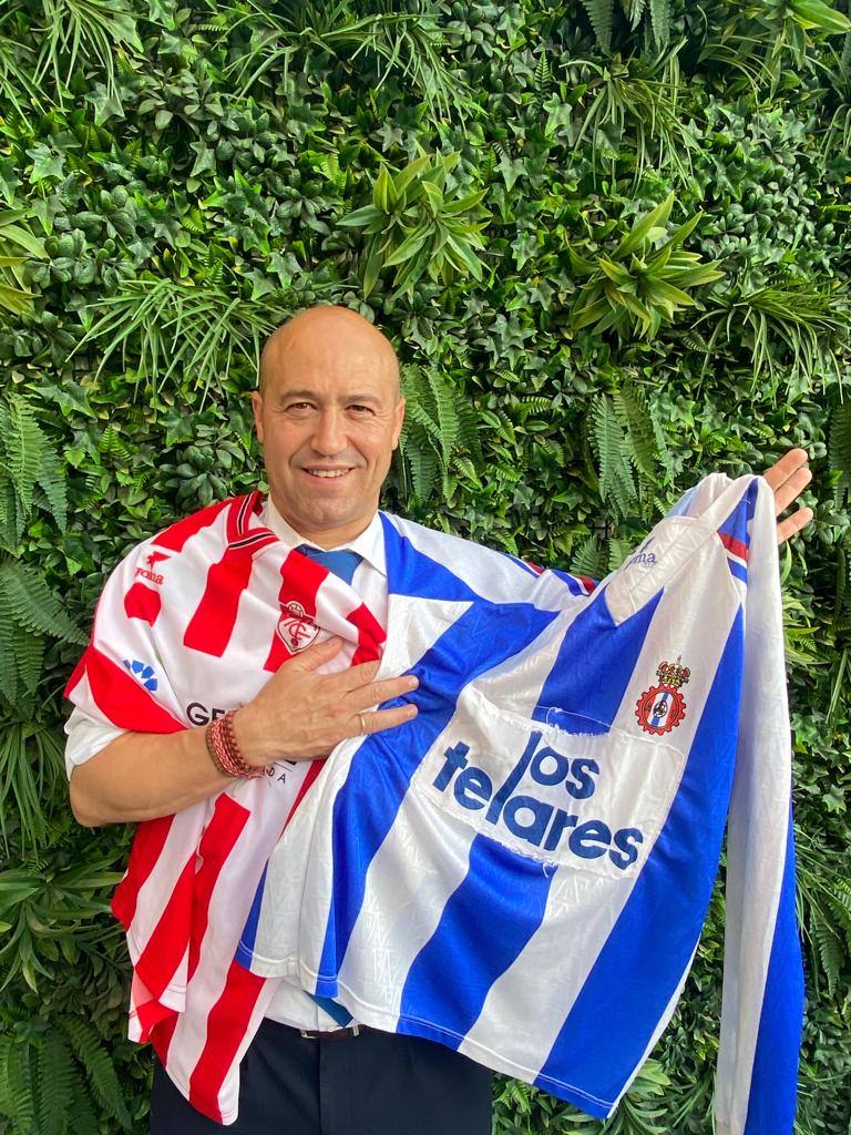 Roberto Fernández posa con las camisetas del Granada, en segundo plano, y del Avilés.