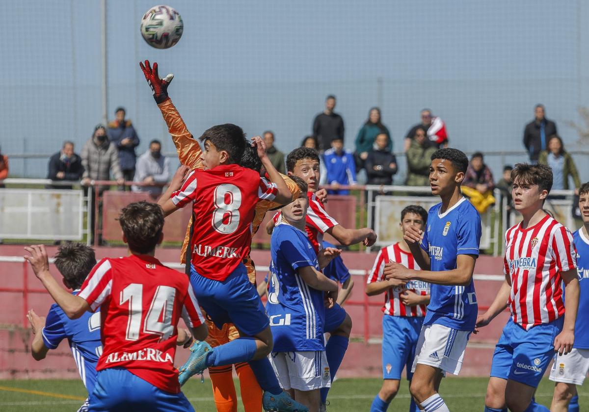 Varios jugadores infantiles tratan de alcanzar un balón durante la disputa de un Sporting-Oviedo.