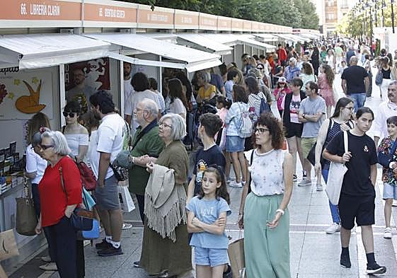 Aluvión de gente en el primer día de la Feria del Libro de Gijón, en el paseo de Begoña.