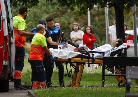 Sanitarios y policías trasladan al herido por arma blanca.