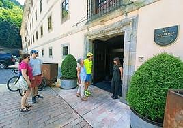 Varios huéspedes esperan para registrarse en el Parador Monasterio de Corias, en Cangas del Narcea.
