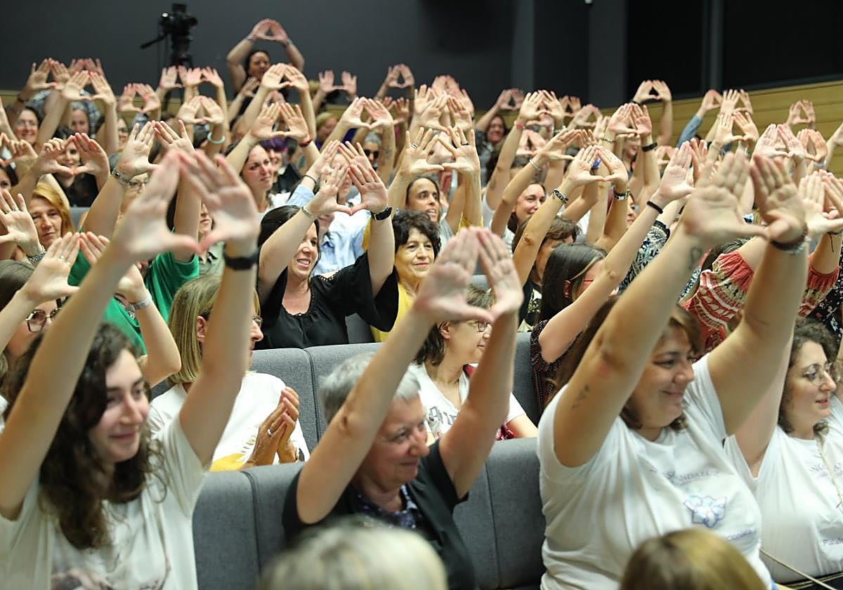 La concurrencia hace con las manos el símbolo del feminismo.
