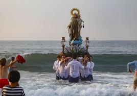 Los cofrades sacan a la Virgen de las aguas del Cantábrico.
