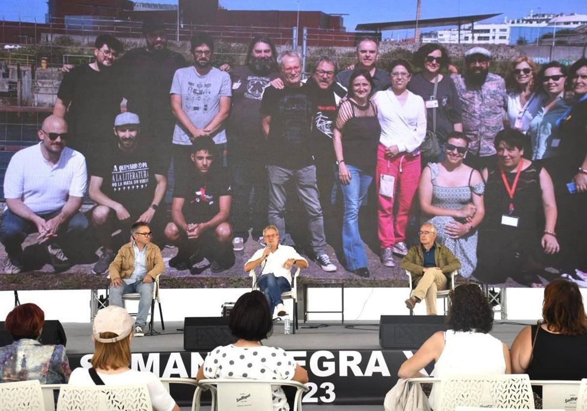 El concejal Gilberto Villoria, Ángel de la Calle y Antón García, en la clausura de la Semana Negra, con la foto del equipo del festival de fondo.