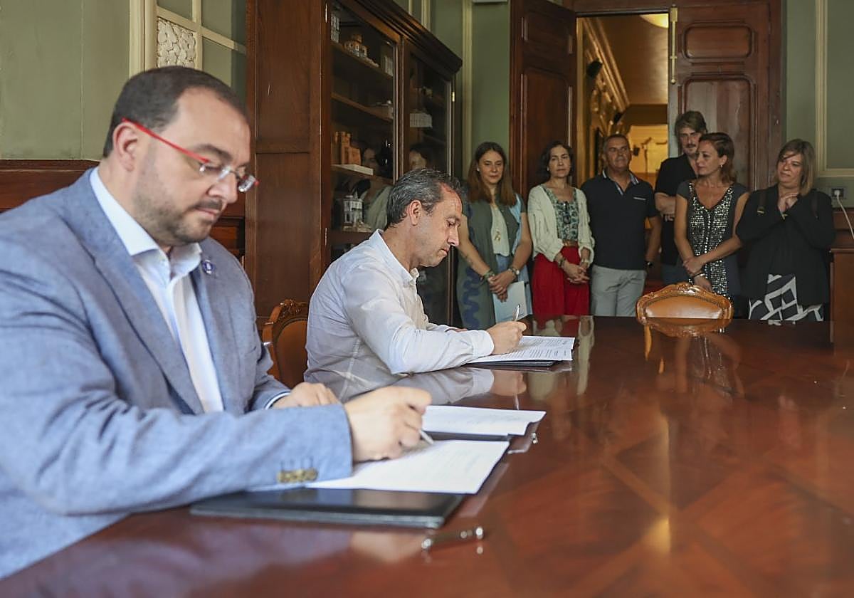 Adrián Barbón y Ovidio Zapico suscriben el acuerdo en presencia de María José Miranda, Dolores Carcedo, Maximino García, Xabel Vega, Delia Campomanes y Gimena Llamedo.
