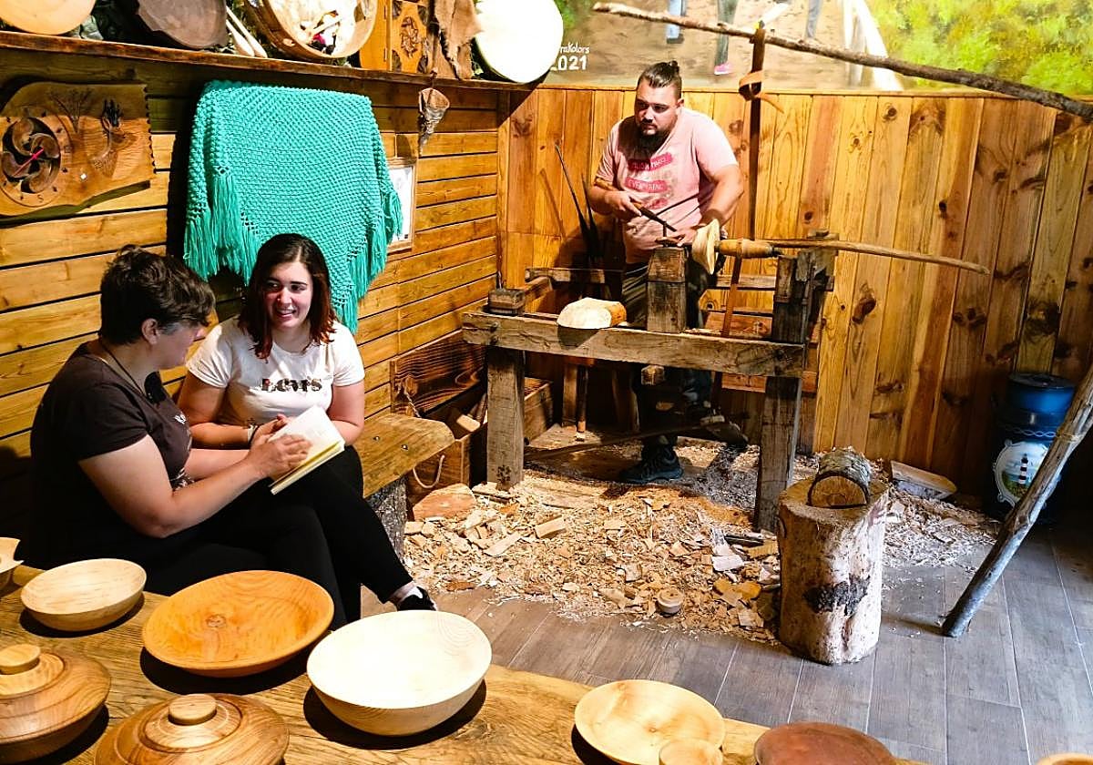 Tradición ancestral. Víctor 'el Cunqueiro', al fondo, trabajando con el torno de pedal con el que elabora sus productos.