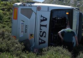 Un agente de la Guardia Civil, junto al autobús accidentado.