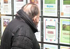 Un hombre mira las ofertas de venta en una inmobiliaria.