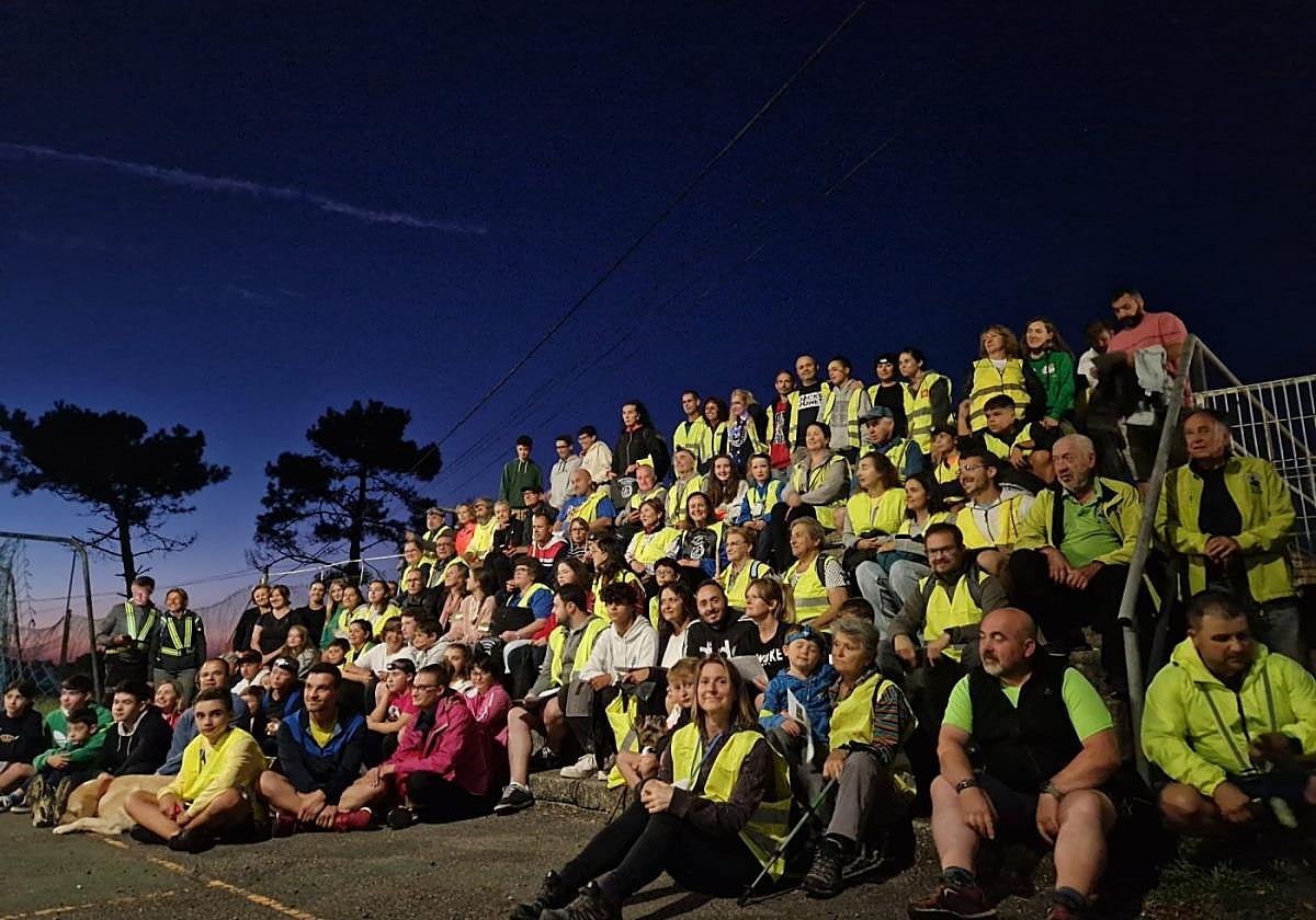 Los participantes en la ruta nocturna de La Chiruca, en la grada del campo de fútbol de Valdredo.