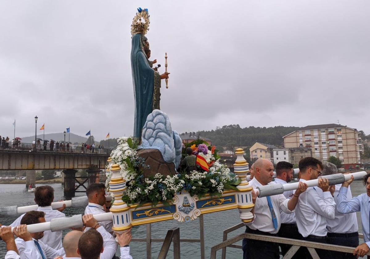 Nuestra Señora de la Barca es embarcada para realizar la tradicional procesión marinera en Navia .