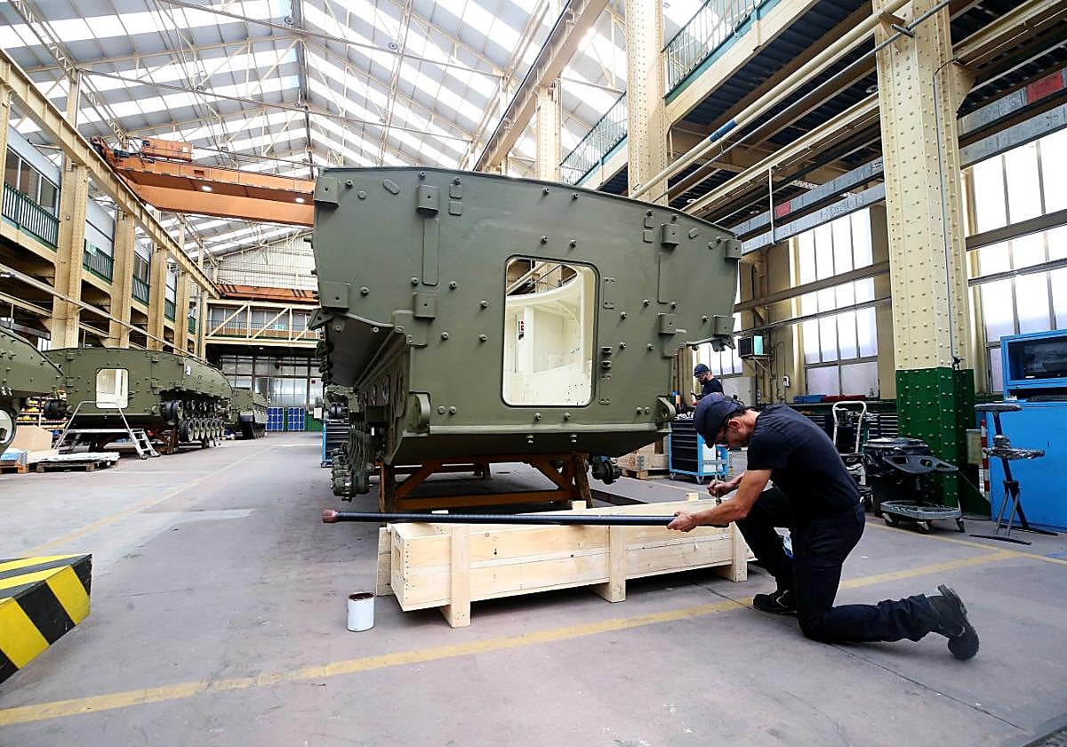 Varios operarios de la fábrica de armas de Trubia trabajan en un blindado.