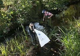 Los vecinos limpian el río en una edición pasada de la actividad.