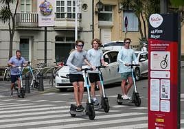 Usuarios de patinetes eléctricos circulan por el centro de Gijón.