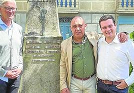 Marcos Niño, Luis López y Sergio Martínez, con el monolito del los Pueblos de Asturias de Navelgas en el que desde ayer figura también Santa Eulalia de Oscos.