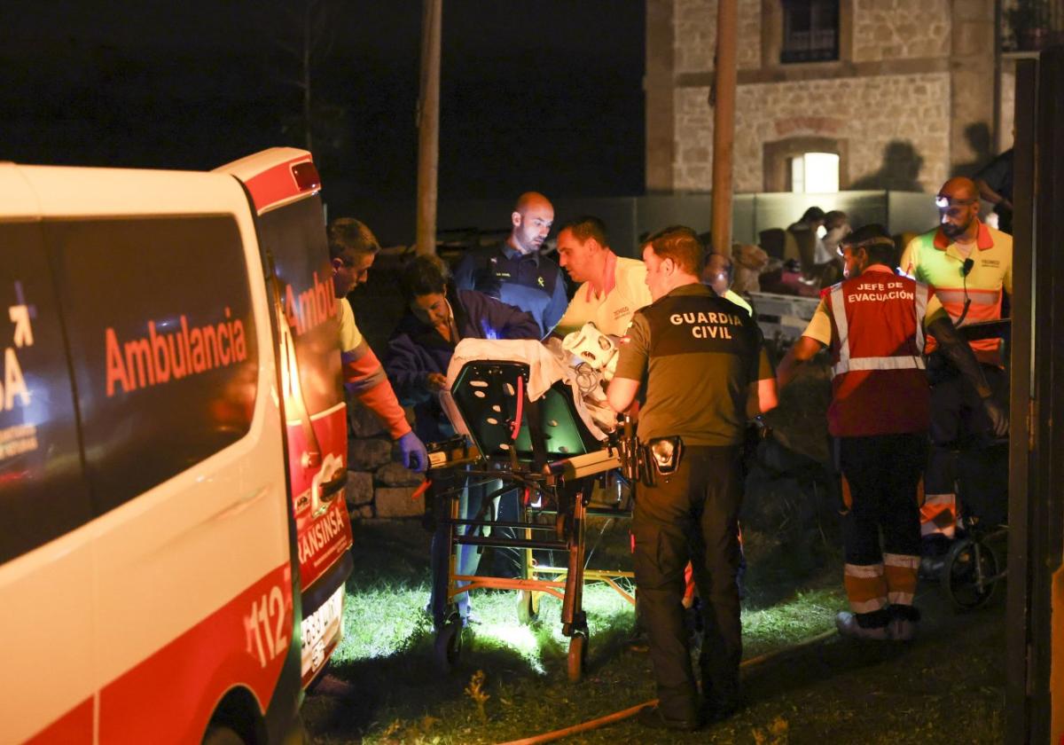 Sanitarios, bomberos y guardias civiles atienden a un herido.