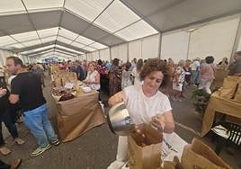 Ana Isabel Fernández, de la Matosa, echa avellanas en una bolsa para su venta.