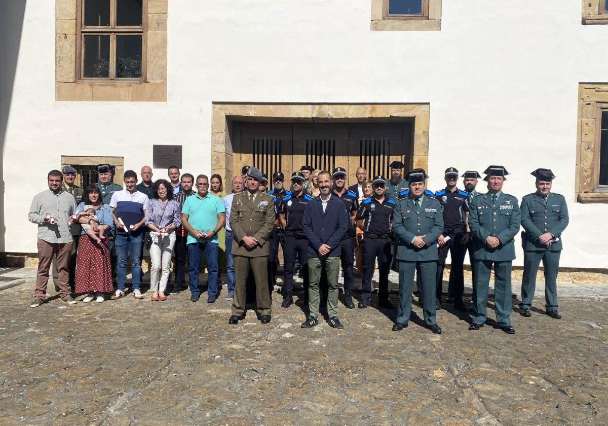 Vecinos, Policía Local, Guardia Civil y miembros del Ayuntamiento posan en el patio del Palacio Marqués de Santa Cruz de Pola de Siero.