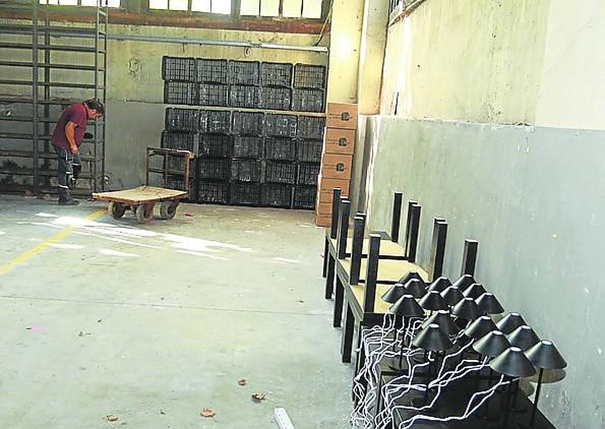 Imagen secundaria 1 - Dos operarios colocan los marcos donde se expondrán los trabajos de 'Toma la palabra'. Estanterías, lámparas y mesas darán forma al 'jazz kissa', en honor a Murakami. Un trabajador accede a la Nave Almacén, en plena transformación. 