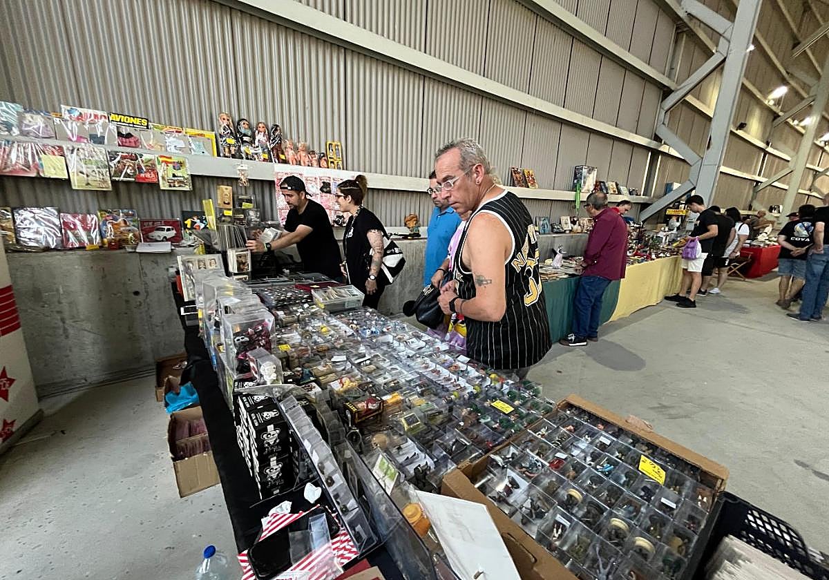 Aficionados al coleccionismo revisan los productos expuestos en uno de los más de cien puestos de la feria de Mieres.