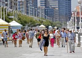 Distintas generaciones, de paseo por el Muro de San Lorenzo, en Gijón.