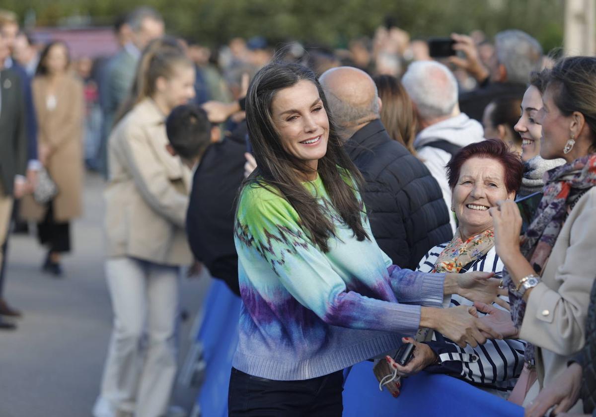 La Reina Letizia saluda a algunas vecinas en su visita a las parroquias de Arroes, Peón y Candanal.