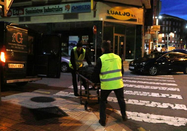 Los servicios funerarias trasladan el cadáver del joven fallecido en el edificio de la calle Avilés.