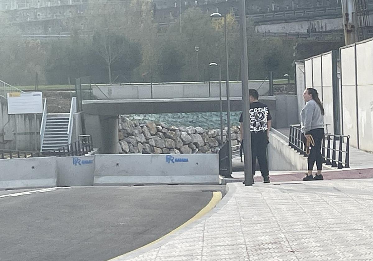 Una pareja se dirige al paseo fluvial del río Nalón desde el nuevo paseo peatonal.
