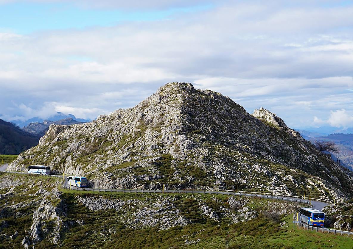 Imagen principal - 1) Tres buses agrupados bajando por el tramo del mirador de la Reina, en torno a la una de la tarde. 2) Amigos de Madrid en el mirador de Entrelagos. 3) El taxi no está sujeto al sistema de reserva previa. 