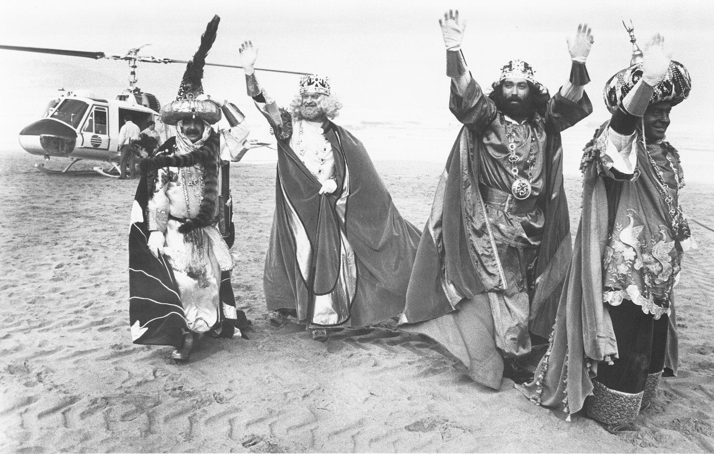 Aliatar, Melchor, Gaspar y Baltasar saludan a los gijoneses tras aterrizar en helicóptero sobre la arena de la playa de San Lorenzo.