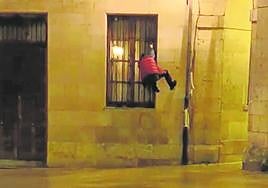 Un joven trepa la fachada del ayuntamiento de Oviedo.
