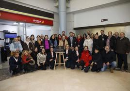 Compañeros de Ángel Suárez-Valdés (con jersey malva su hermana Mati), rodean la placa que colocaron en la sala de Iberia.