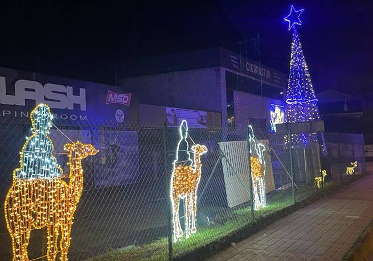 Los Reyes Magos camino del Belén colocado en la fachada y el árbo, al fondo.