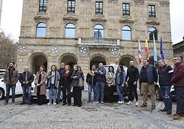 Representantes de las cooperativas del taxi participantes en la iniciativa solidaria posan en la plaza Mayor con el edil Pelayo Barcia.