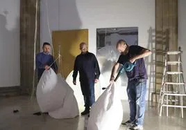 Ramón Isidoro, en el centro, ultima los detalles de la instalación que hoy se abre en el Museo Barjola de Gijón.