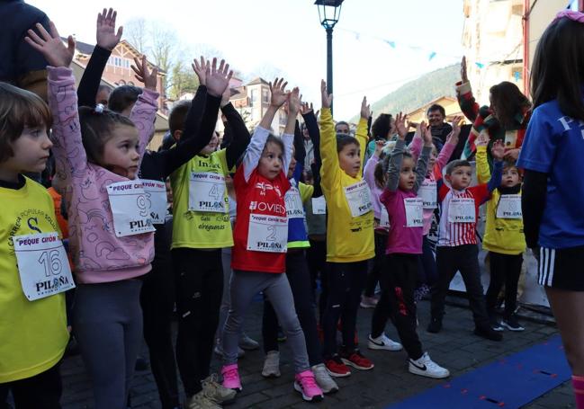 Participantes del Peque Trail del Cayón calentando músculos antes de tomar la salida en la edición 2023