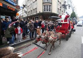 Papá Noel, acompañado por siete elfos y seis renos, en 2021, en el primer pasacalles por el centro de Oviedo.