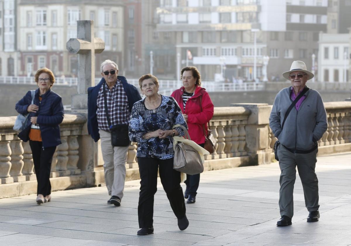 Un grupo de personas mayores pasea por el Muro de San Lorenzo.