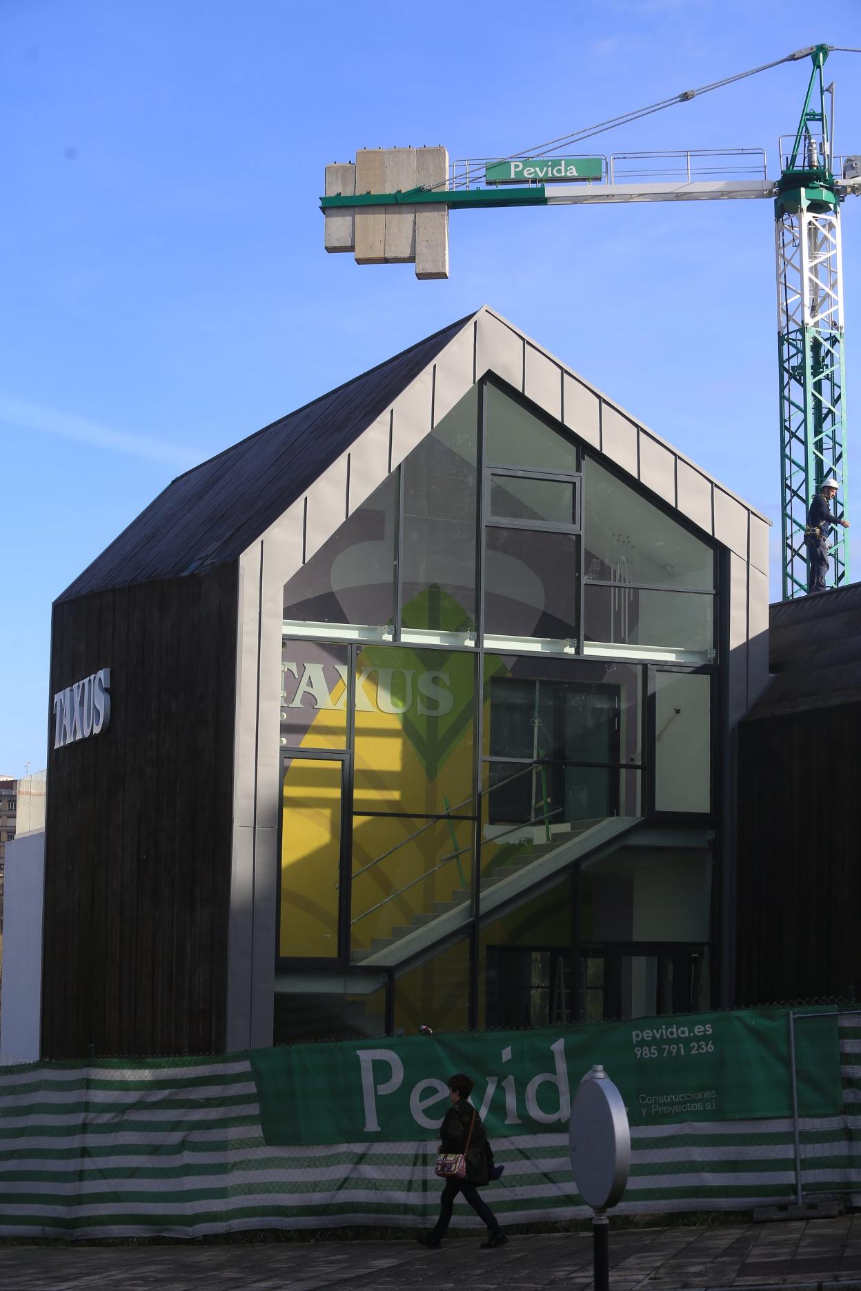 Una mujer pasea junto a la nueva sede de Taxus en Montecerrao. 