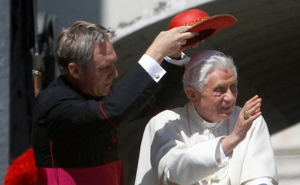 Georg Gänswein sujeta un sombrero ante Benedicto XVI.