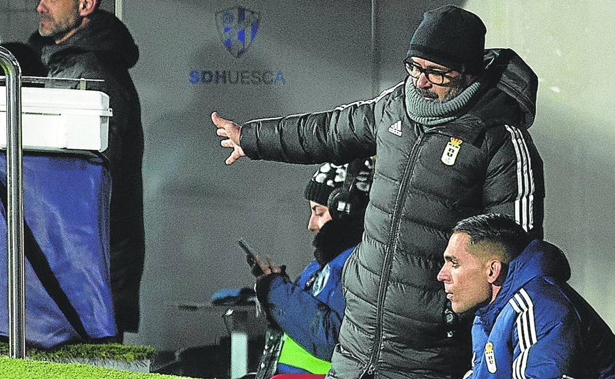 El entrenador del conjunto ovetense, Álvaro Cervera, comenta el encuentro ante el Huesca en el banquillo de El Alcoraz con el segundo entrenador del equipo, Roberto Perera.