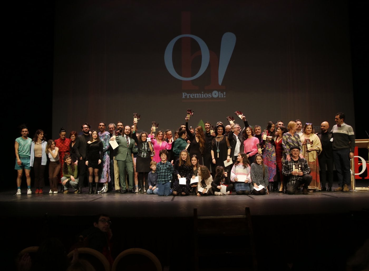 Foto de familia de los premiados y entregadores de premios en el escenario del Teatro Jovellanos.