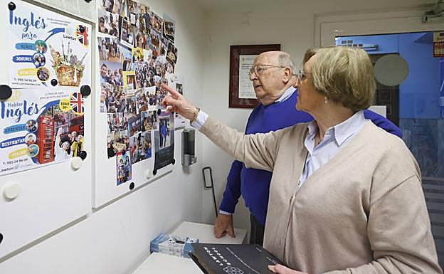 Maureen y Edwin repasan fotos en la entrada del centro de la Plazuela, su primer centro en Gijón.