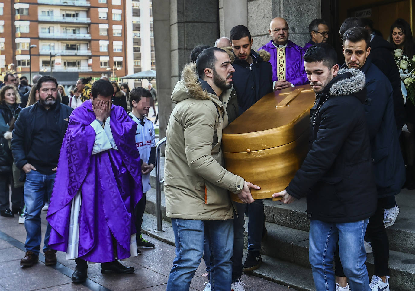 Pedro Fernández, que ofició la ceremonia observa emocionado como los amigos de Pelayo sacan el feretro de la iglesia. 