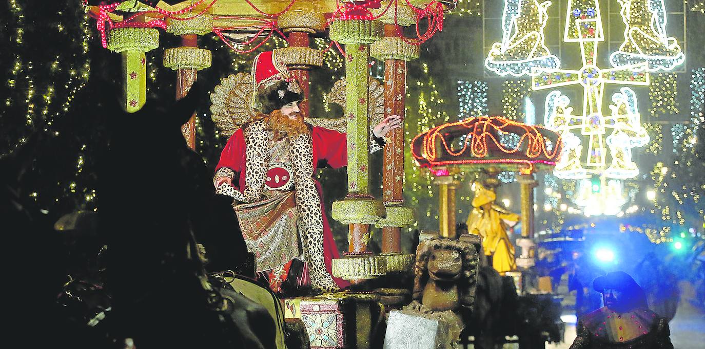 Gaspar, y detrás Baltasar, saludando a las miles de personas congregadas para seguir la cabalgata, a pesar de la lluvia. fotos: alex piña