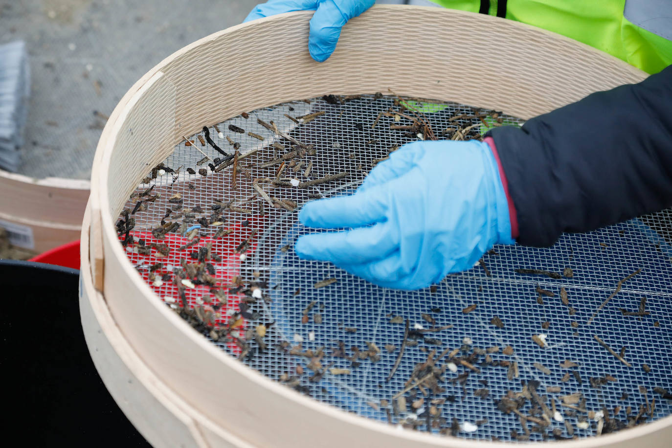 Operarios retiran los pellets o bolitas para fabricar plástico que aparecen en las playas de Asturias, tras la caída de un contenedor de un barco el pasado diciembre, esta mañana en la playa asturiana del Aguilar.