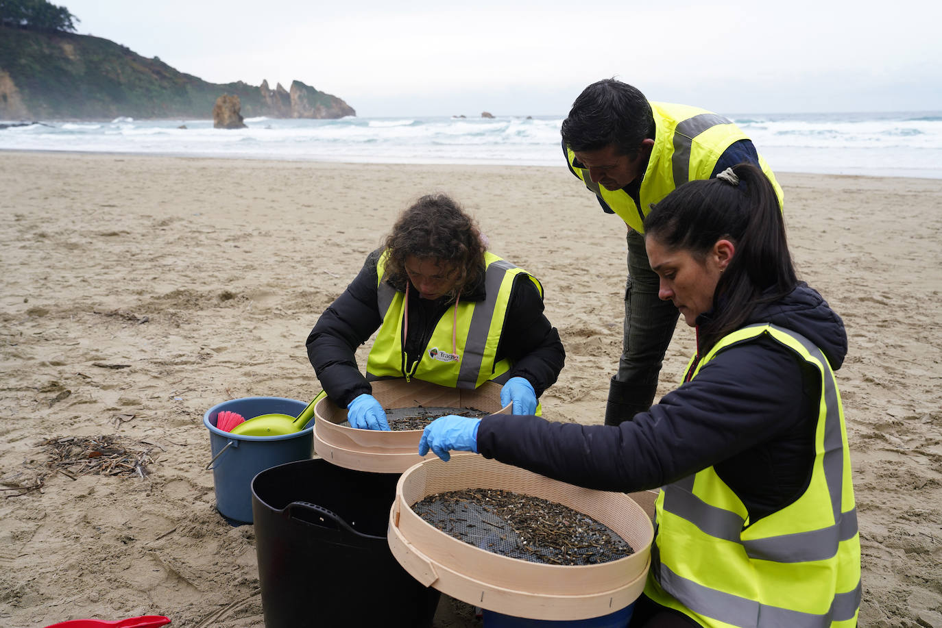 Labores de limpieza, este martes, de pélets en la playa del Aguilar, en Muros de Nalón.